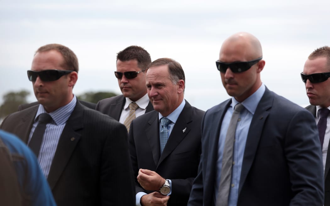210214. Photo Diego Opatowski / RNZ. Prime Minister John Key arrives surrounded by security.