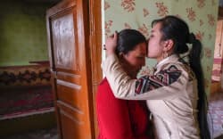Buzeynep Abulehet,the eldest daughter of a family of six, kisses her mother before leaving for work, at her home in Moyu of Hotan Prefecture, northwest China’s Xinjiang Uygur Autonomous Region, March 26, 2020.