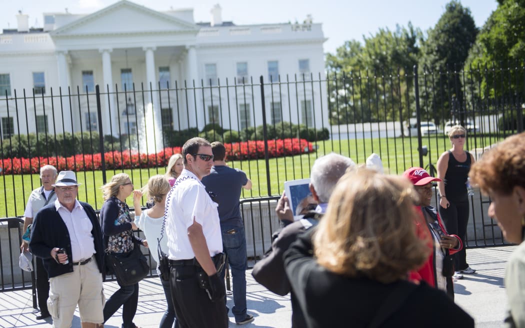 A member of the Secret Service's  uniformed division patrols outside the White House.