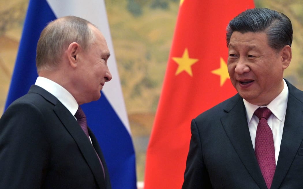 Russian President Vladimir Putin (L) and Chinese President Xi Jinping arrive to pose for a photograph during their meeting in Beijing, on February 4, 2022. (Photo by Alexei Druzhinin / Sputnik / AFP)