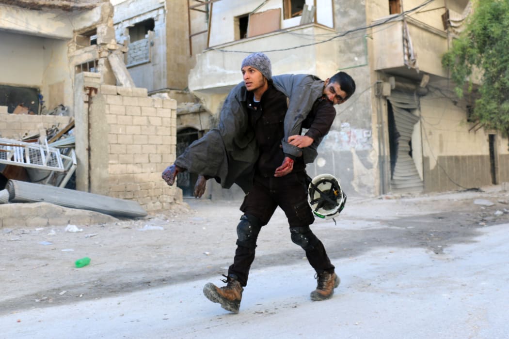 A Syrian civil defence volunteer, known as the White Helmets, carried an injured man following air strike on Aleppo's rebel-held neighbourhood of Bab al-Nayrab.