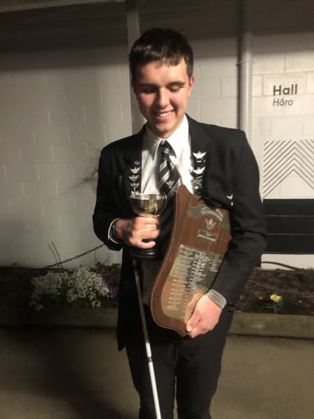 Toby Ireland holds a trophy for Hutt Valley High School's 'Top Sportsperson' award.