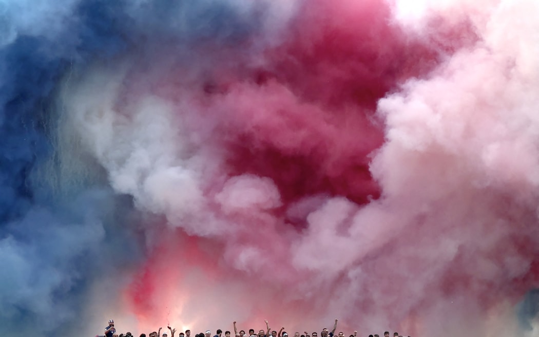 Fireworks explode as Paris Saint-Germain's players parade on a bus on the Champs-Elysees avenue in Paris on June 1, 2025, a day after PSG won the 2025 UEFA Champions League final football match against Inter Milan in Munich.