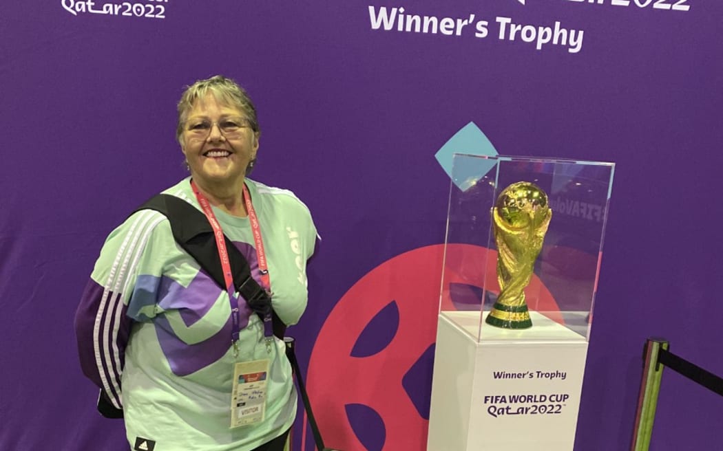 Volunteer Diane Weston from Tauranga up close with the FIFA World Cup trophy in Doha.