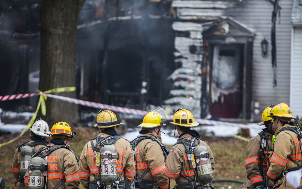 Firefighters inspect the scene after a small passenger plane crashed into a residential area, engulfing one home in flames and damaging two others in Gaithersburg, USA.