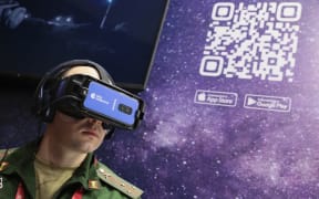 A serviceman wearing virtual reality glasses watches the presentation of RIA Lab VR projects at a stall of Rossiya Segodnya International Information Agency during the Army-2021 International military-technical forum in the Patriot Park in Kubinka, Moscow.