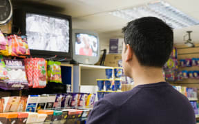 Man watching television in shop (Photo by NEIL GUEGAN / Connect Images / Connect Images via AFP)