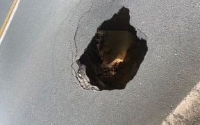 The hole in the road.