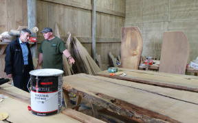 Nathan Guy examines kauri slabs and table tops with Kaihu mill and gallery owner Nelson Parker.