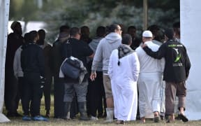People gather at the cemetery as funerals for victims of the mosque attack are due to take place.