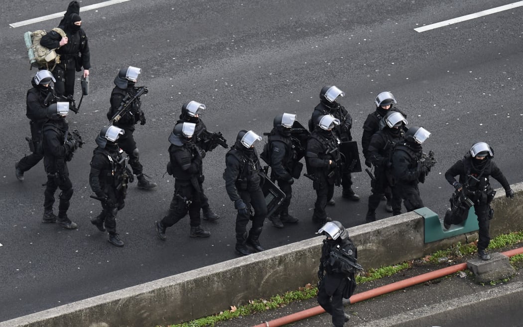 Members of the French police special force RAID walk on the "peripherique" (circular road) before taking their positions.