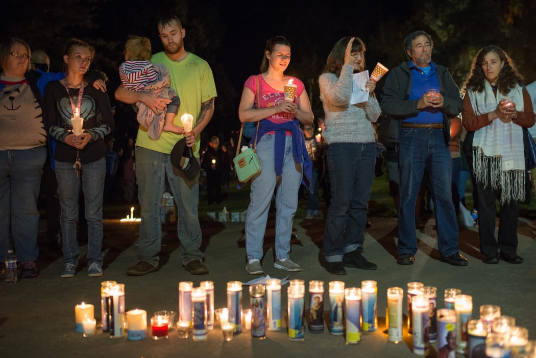 People pray during a candlelight vigil in Roseburg,Oregon for ten people killed and seven others wounded in a shooting at a community college.