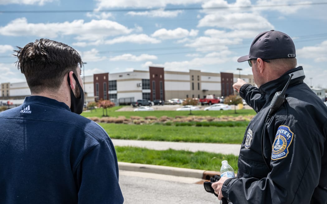 INDIANAPOLIS, IN - APRIL 16: A FedEx employee speaks with a police officer about details relating to his place of work, a FedEx Ground facility, on April 16, 2021 inIndianapolis, Indiana.