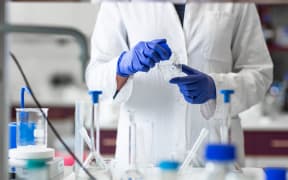 Researcher carrying out scientific research in a lab (shallow DOF; color toned image)