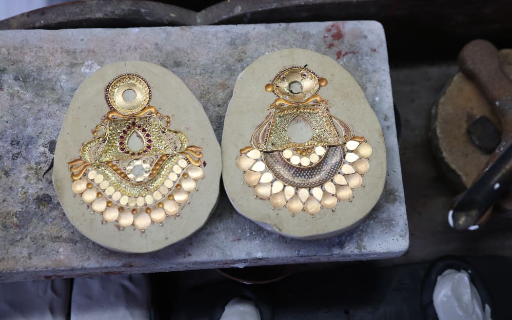 Goldsmiths work on crafting gold ornaments at a workshop ahead of Dhanteras, a Hindu festival associated with Lakshmi, the goddess of wealth, in Kolkata, India, on October 16, 2025. Gold hits a record high today as investors ramp up their safe-haven bets amid rising trade tensions between the world's two largest economies, the US and China. (Photo by Rupak De Chowdhuri/NurPhoto) (Photo by RUPAK DE CHOWDHURI / NurPhoto via AFP)