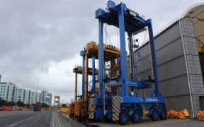The Ports of Auckland is introducing new driver-less container movers. The automated versions is blue, the driven straddle carrier is yellow.