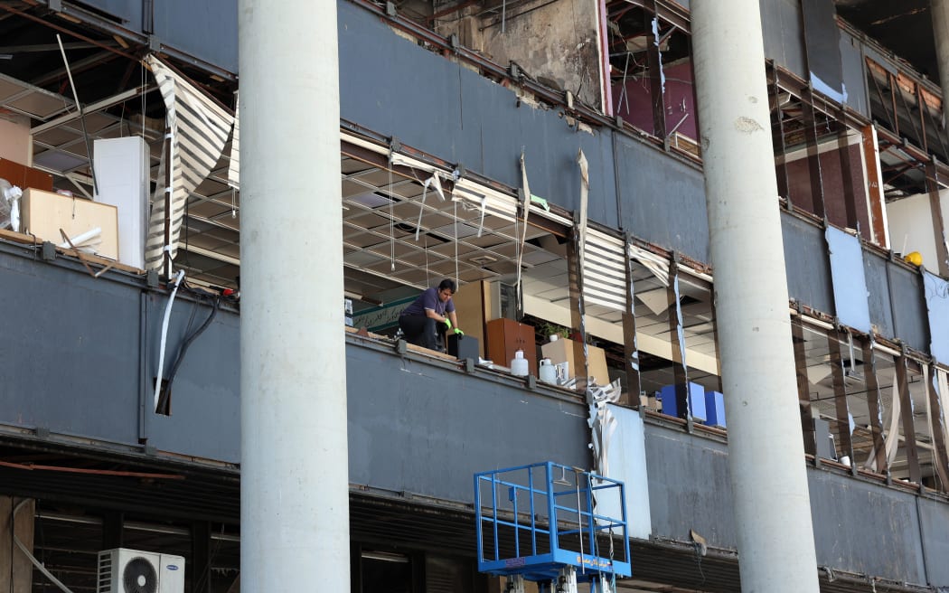 A man checks the site at the heavily damaged building of the Islamic Republic of Iran Broadcasting (IRIB) on 19 June, 2025, after it was hit a few days earlier in an Israeli strike, in Tehran, Iran.