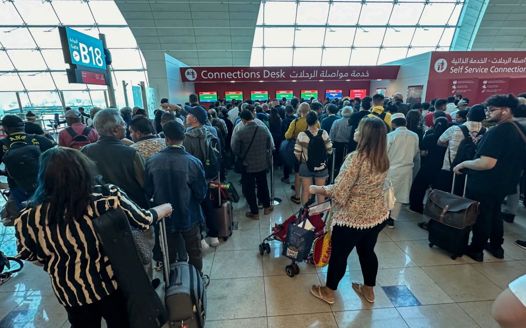 Passengers queue at a flight connection desk at Dubai International Airport on 17 April 2024. Scores of incoming flights had been diverted as heavy rains lashed the United Arab Emirates, causing widespread flooding around the desert country.