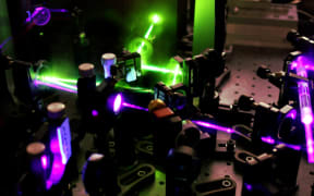 A set of lenses and purple and green lasers