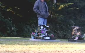A screenshot from a video capturing the alleged offender damaging a headstone in the Rakaia Cemetery.