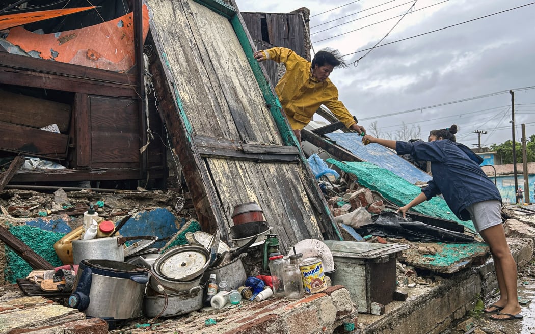 A family salvages belongings from the rubble of their home after it collapsed during Hurricane Melissa’s passage through Santiago de Cuba, Cuba, on 29 October, 2025.