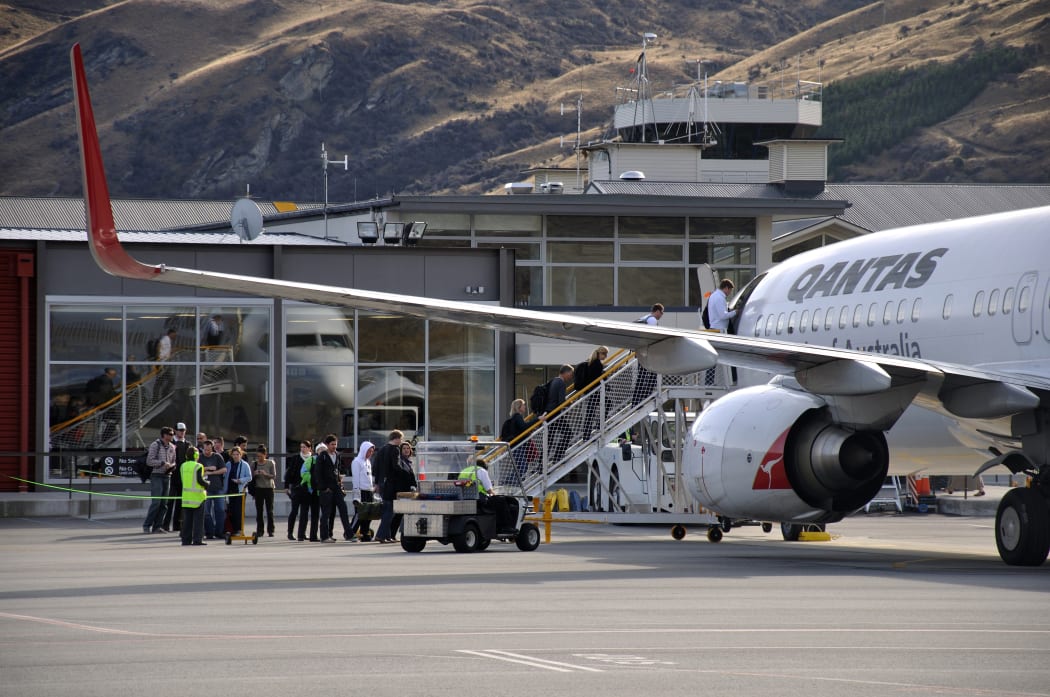 Passengers board commercial jet at Queenstown Airport.
