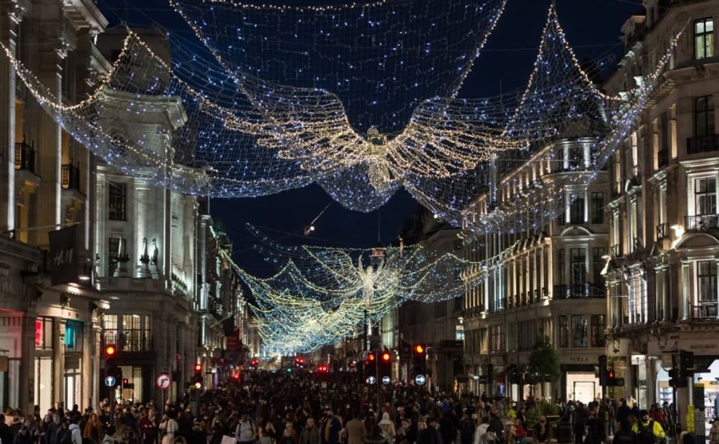 Shoppers walk on Regent Street decorated with festive lights as new coronavirus restrictions, announced today by British Prime Minister Boris Johnson, are due to take effect from midnight on Sunday, on 19 December, 2020 in London, England.