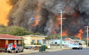 Flames from an out of control bushfire seen from a nearby residential area in Harrington, some 335km northeast of Sydney.