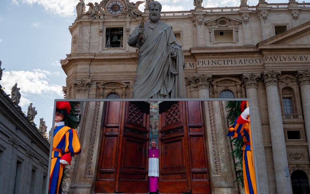 The screen displays footage of the start of the conclave at St Peter's Square in the Vatican, on May 7, 2025. (Photo by Massimo Valicchia/NurPhoto) (Photo by Massimo Valicchia / NurPhoto / NurPhoto via AFP)