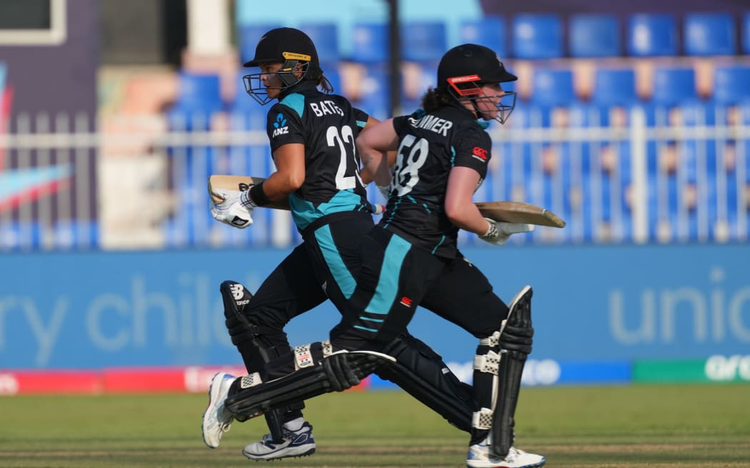 Suzie Bates  and Georgia Plimmer of New Zealand cross during the 2024 T20 World Cup in the UAE.