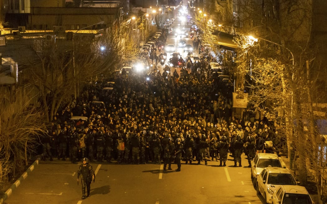 Iranian riot police stand guard as protesters gather in front of Tehran's Amir Kabir University on January 11, 2020.