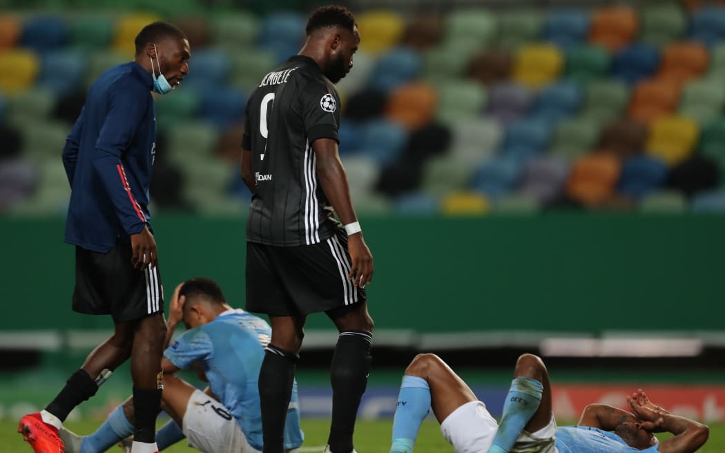 Lyon's French forward Moussa Dembele (2R) looks at Manchester City's players reacting to their defeat at the end of the UEFA Champions League quarter-final football match at the Jose Alvalade stadium in Lisbon on August 15, 2020.