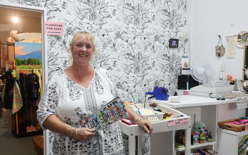 Picture of a woman standing in front of a wall with stenciled wallpaper, she's wearing a matching top.