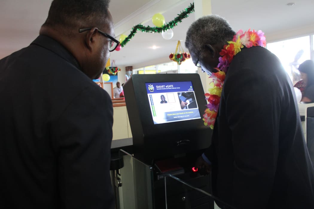 Solomon Islands Prime Minister Manasseh Sogavare (R) tries out the newly launched E-passport and Border Control and Management system. Looking on (L) is the Deputy Prime Minister Manasseh Maelanga.