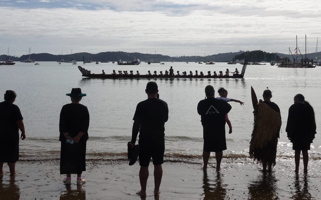 A waka passes Tii Beach during this morning's display.