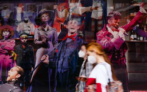 Women wearing face masks walk past the closed closed Sondheim Theatre, home to long-running musical 'Les Miserables', on Shaftesbury Avenue in London, England, on July 6, 2020.