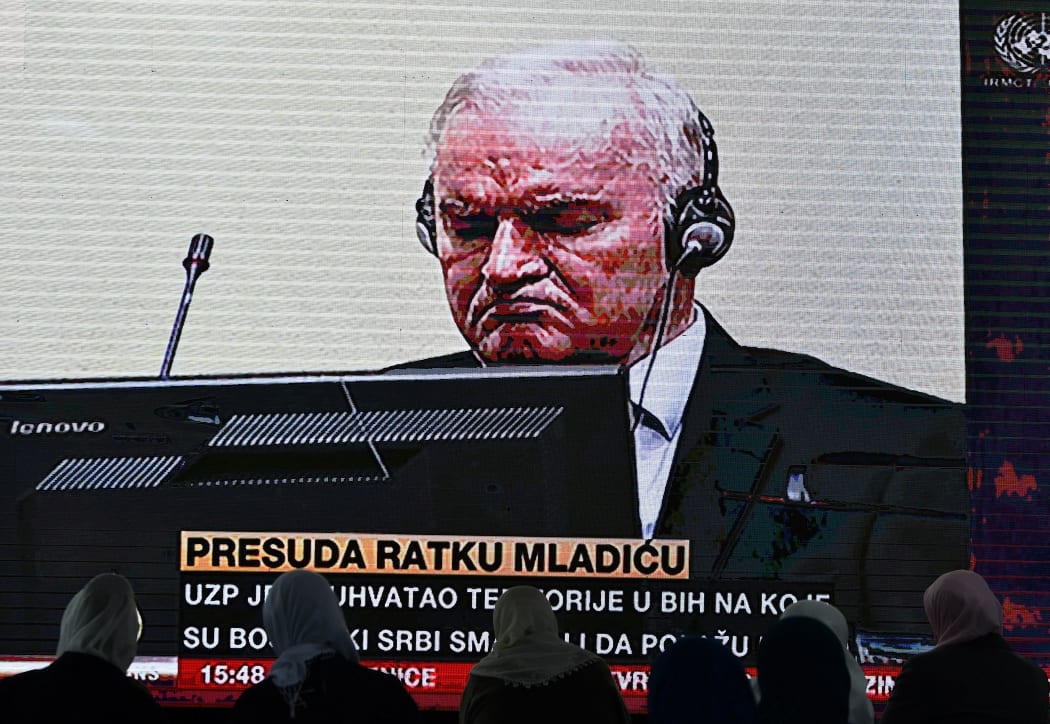 Former Bosnian Serb military chief Ratko Mladic (C) appears on the screen of a live television broadcast from The Hague in the Netherlands.