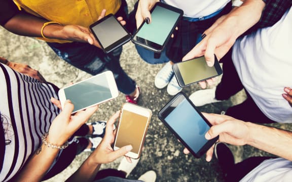 Diverse friends using their phones.