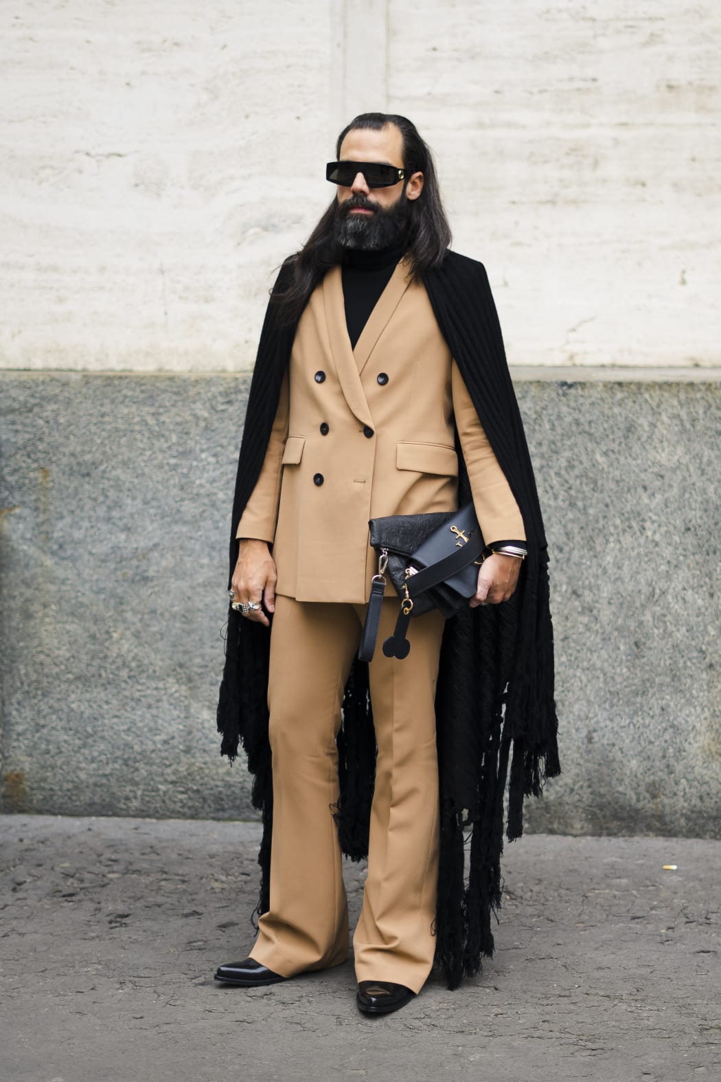 A guest is seen wearing beige suit, cape with fringes outside M1992 during Milan Menswear Fashion Week Autumn/Winter 2019/20 on January 12, 2019 in Milan, Italy. (Photo by Nataliya Petrova/NurPhoto) (Photo by Nataliya Petrova / NurPhoto / NurPhoto via AFP)