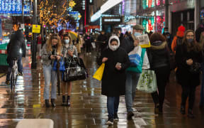 Shoppers walk along Oxford Street as new coronavirus restrictions, announced today by British Prime Minister Boris Johnson, are due to take effect from midnight on Sunday