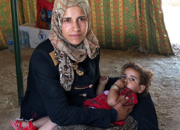 A mother holding her child at camp near Baghdad, set up to shelter people fleeing violence around the city of Falluja.