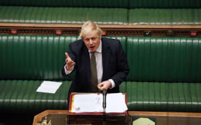 A handout photograph released by the UK Parliament shows shows Britain's Prime Minister Boris Johnson attending Prime Minister's Question time (PMQs) in the House of Commons.