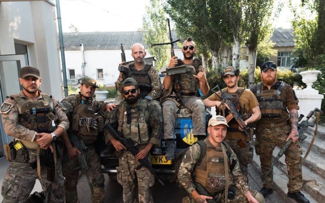 A group of men wearing camoflage gear and holding guns.