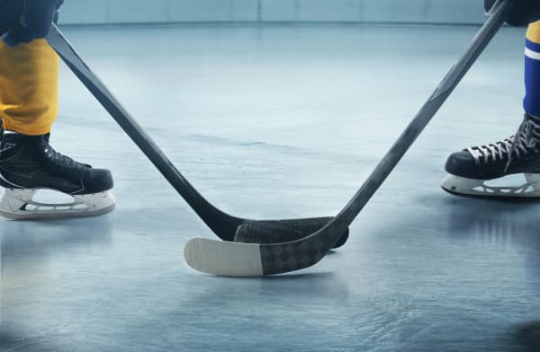 Two ice hiockey sticks facing each other.