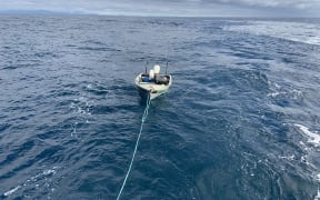 The dingy which made the trip across Cook Strait is towed to safety.