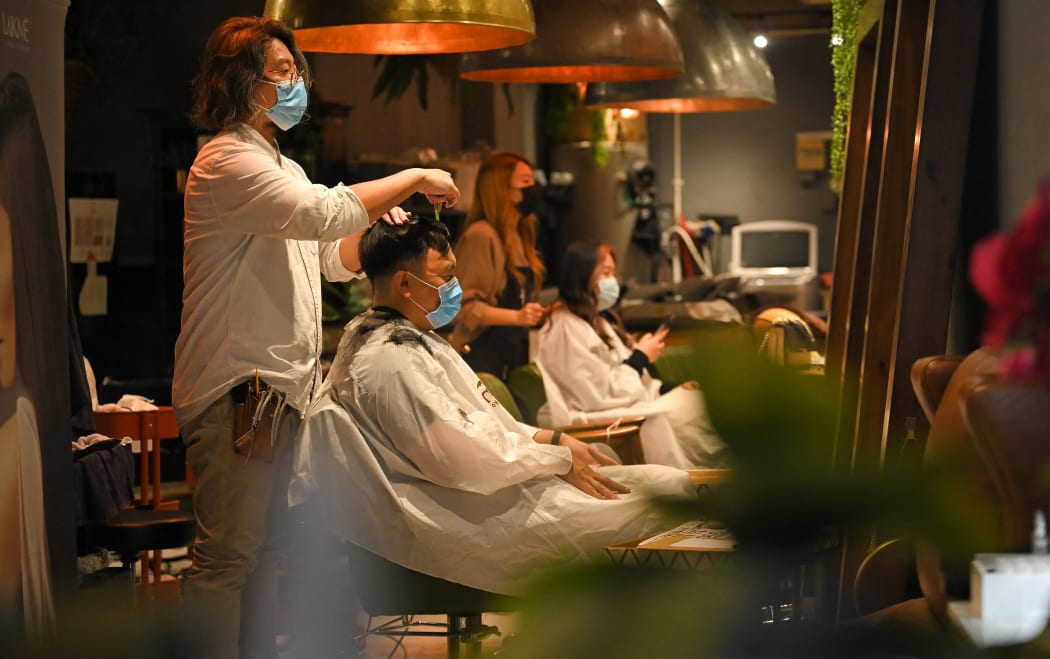 People have their cut at a salon in Sydney on October 11, 2021, as Sydney ended their lockdown against the Covid-19 coronavirus after 106 days.