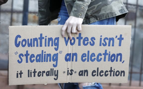 A protestor who wants every vote counted from the 2020 presidential election, carries a sign as they march down Woodward Avenue on November 4, 2020 in Detroit, Michigan.