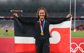 Gold-winning NZ Women's Sevens player Portia Woodman at the Tokyo Olympics bearing the Tino Rangatiratanga flag.