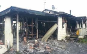 The gutted remains of the Awa Street house. Eight people escaped the fire.