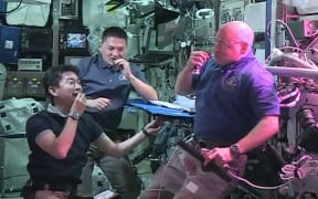Astronauts (from left) Kimiya Yui, Kjell Lindgren and Scott Kelly eat red romaine lettuce grown on board the International Space Station.